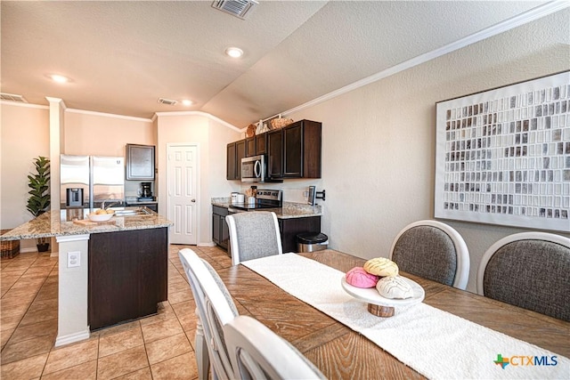 tiled dining room with a textured ceiling, sink, lofted ceiling, and ornamental molding