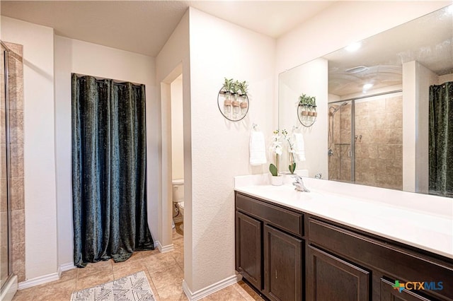 bathroom with tiled shower, tile patterned flooring, vanity, and toilet