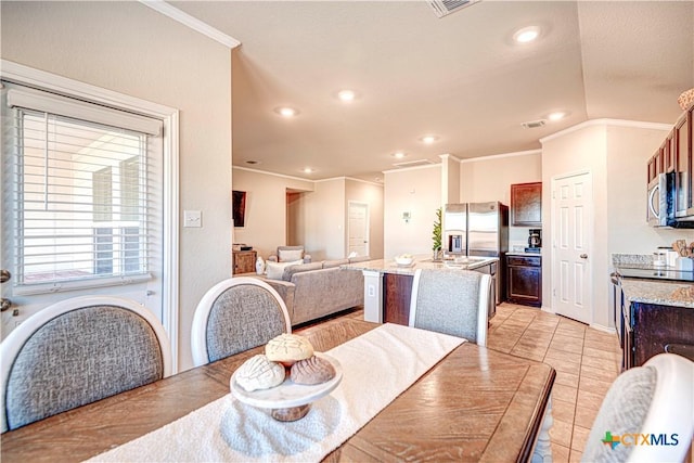 tiled dining room featuring crown molding