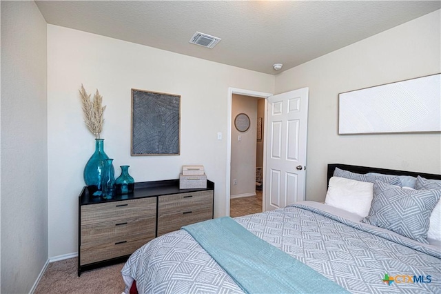 carpeted bedroom with a textured ceiling