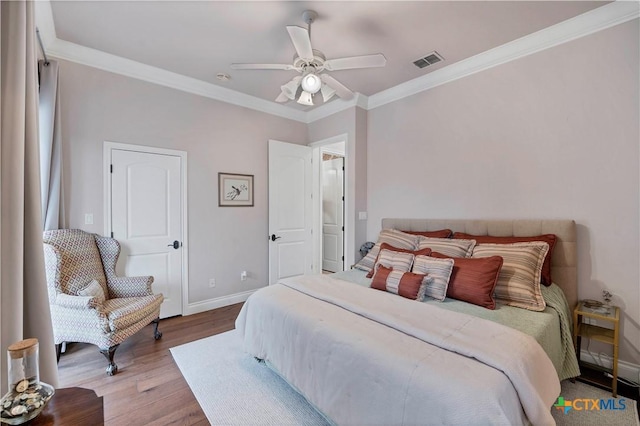 bedroom featuring wood-type flooring, ornamental molding, and ceiling fan