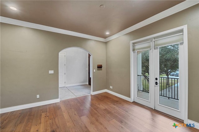 unfurnished room with french doors, crown molding, and light hardwood / wood-style flooring