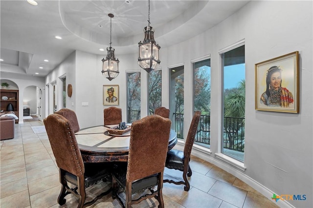 dining area with light tile patterned floors and a raised ceiling