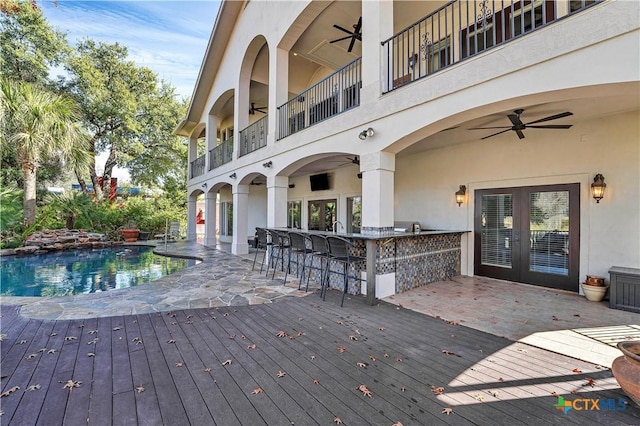 deck with ceiling fan and exterior bar