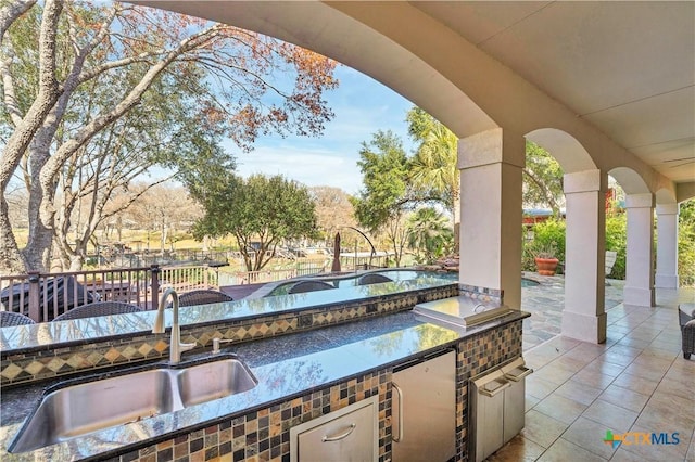 view of patio featuring an outdoor kitchen and sink