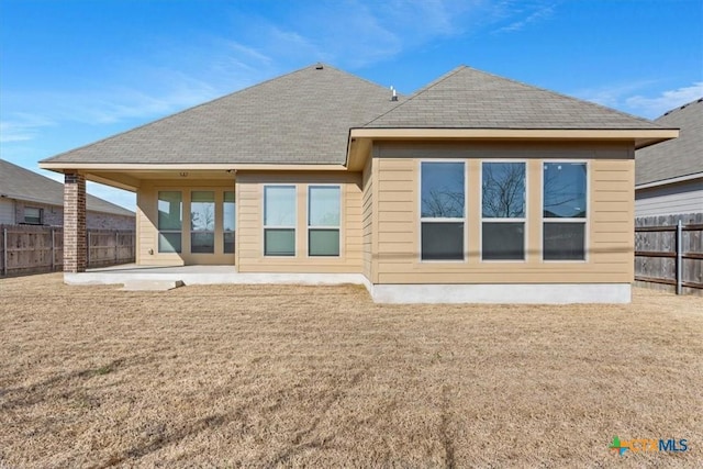 rear view of house featuring a yard and a patio area