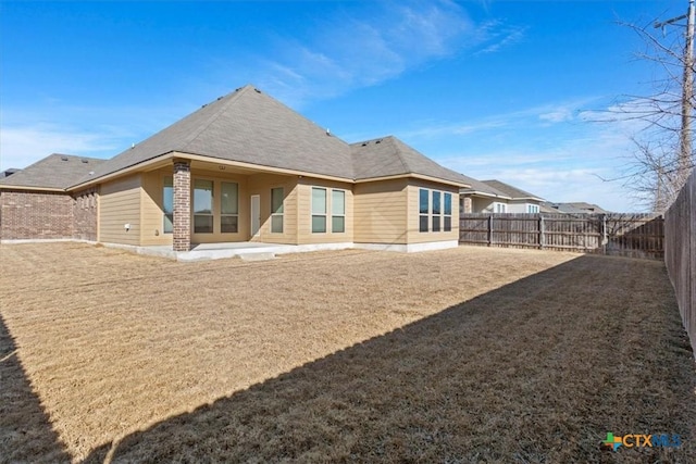 rear view of property with a patio and a lawn