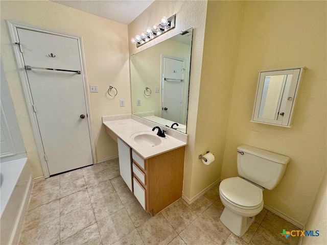 bathroom featuring vanity, tile patterned floors, a bathtub, and toilet