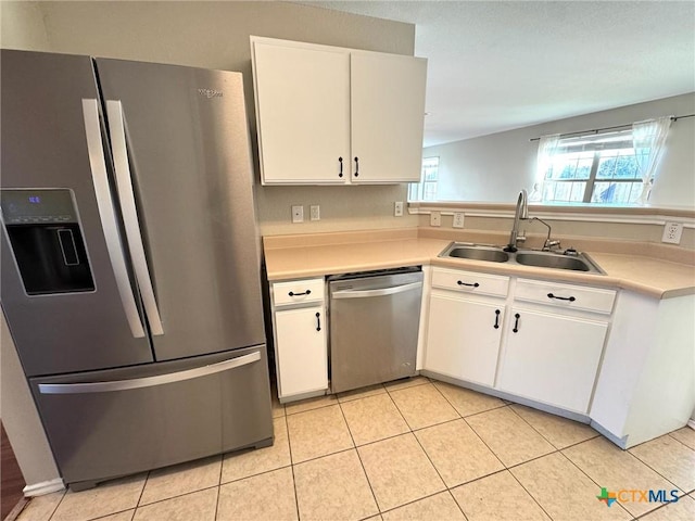 kitchen featuring light tile patterned floors, stainless steel appliances, sink, and white cabinets