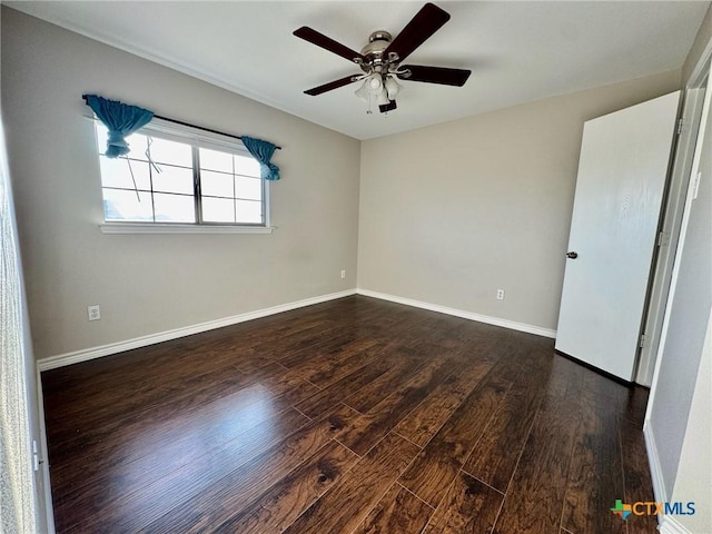 spare room featuring dark wood-type flooring and ceiling fan