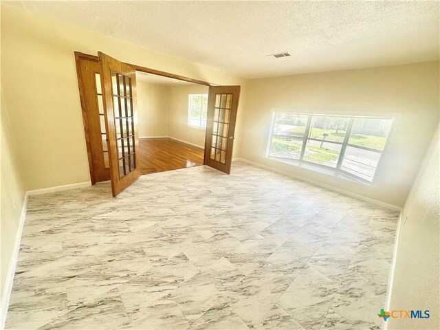 909 S 23rd St, Copperas Cove, TX 76522 - spare room with french doors, baseboards, and a textured ceiling
