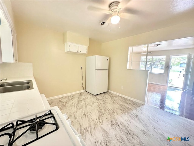 909 S 23rd St, Copperas Cove, TX 76522 - kitchen with freestanding refrigerator, a ceiling fan, baseboards, light countertops, and a sink