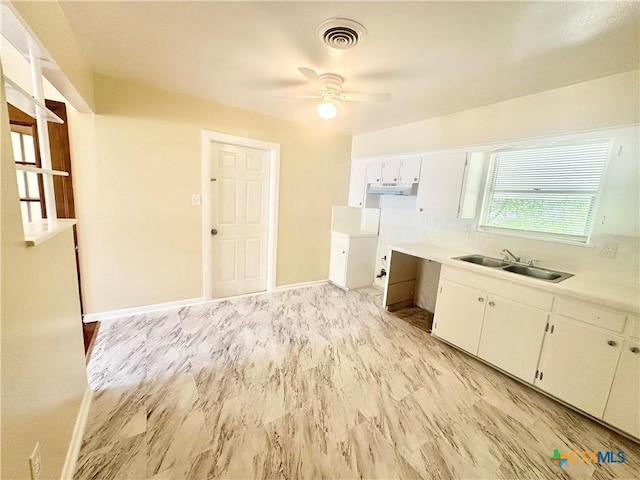 909 S 23rd St, Copperas Cove, TX 76522 - kitchen featuring a sink, a ceiling fan, white cabinetry, light countertops, and under cabinet range hood