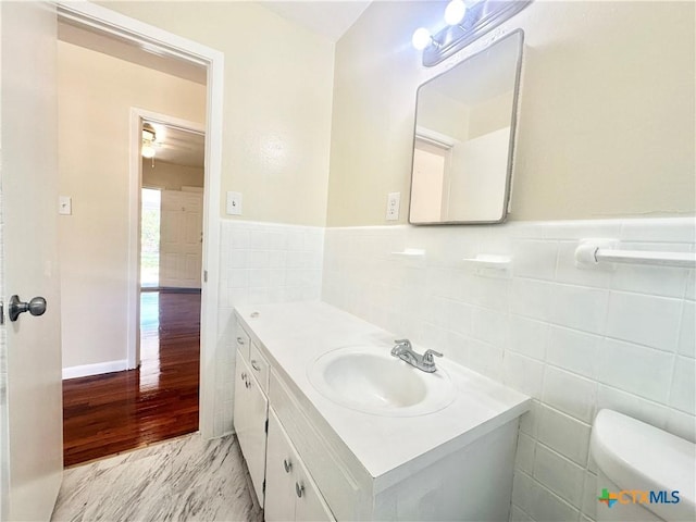 909 S 23rd St, Copperas Cove, TX 76522 - bathroom featuring vanity, tile walls, wainscoting, and toilet