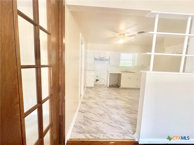 909 S 23rd St, Copperas Cove, TX 76522 - hall featuring baseboards, a sink, and light marble finish flooring