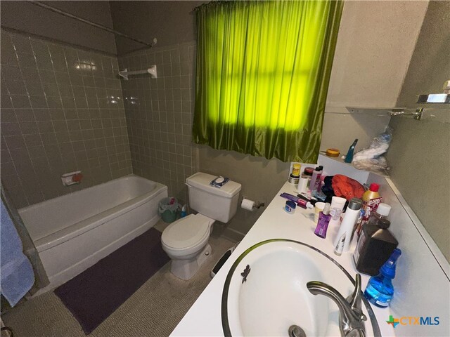 full bathroom with toilet, tiled shower / bath combo, and vanity