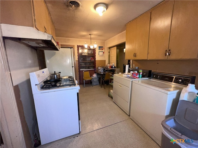 kitchen with washing machine and clothes dryer, white appliances, pendant lighting, and a notable chandelier