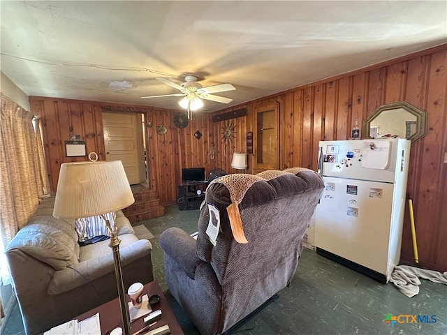 living room featuring wood walls and ceiling fan