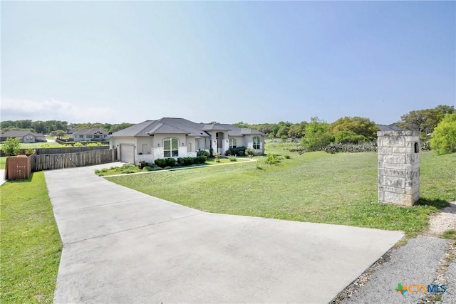 french country inspired facade featuring a front lawn, driveway, fence, and a garage