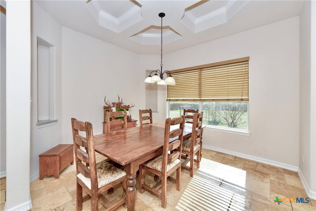 dining space with a notable chandelier, coffered ceiling, stone tile flooring, and baseboards