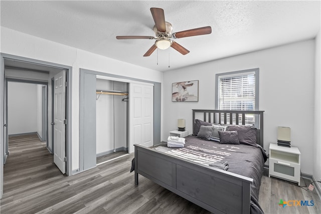 bedroom featuring ceiling fan, a textured ceiling, a closet, and dark hardwood / wood-style flooring