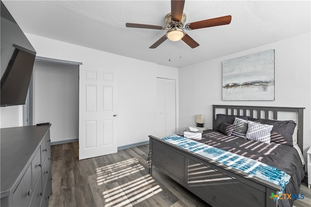 bedroom with a textured ceiling, dark hardwood / wood-style flooring, and ceiling fan