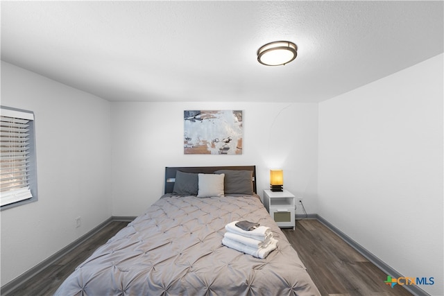 bedroom with dark wood-type flooring