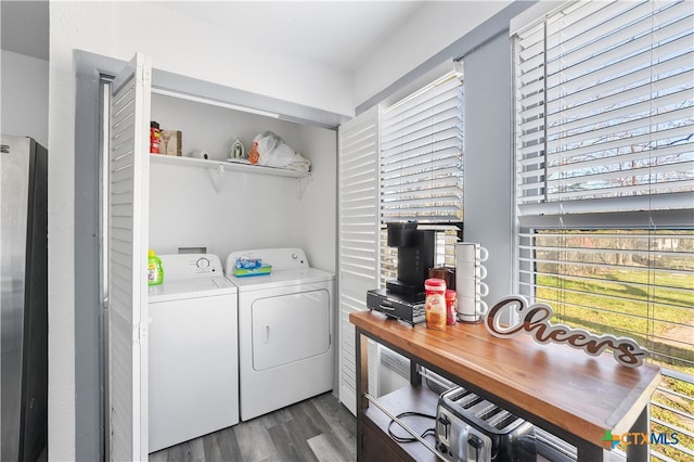 washroom with dark hardwood / wood-style flooring and washing machine and dryer