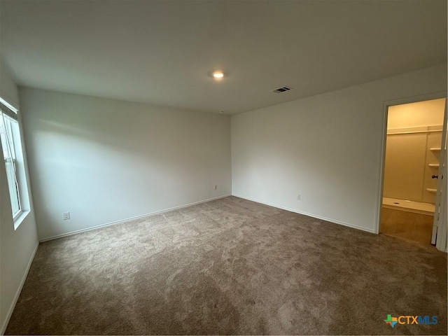 unfurnished bedroom featuring baseboards, carpet, and visible vents