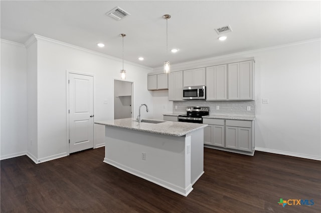 kitchen featuring sink, stainless steel appliances, dark hardwood / wood-style flooring, pendant lighting, and a center island with sink