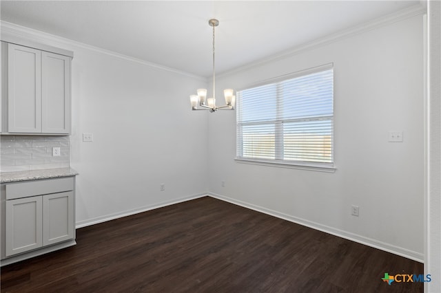 unfurnished dining area featuring dark hardwood / wood-style flooring, a chandelier, and ornamental molding