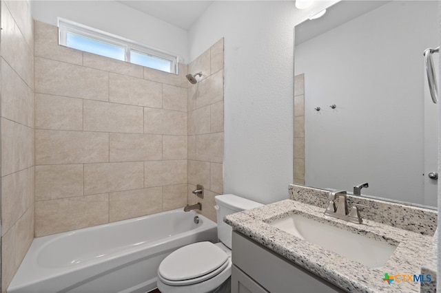 full bathroom featuring tiled shower / bath combo, toilet, and vanity