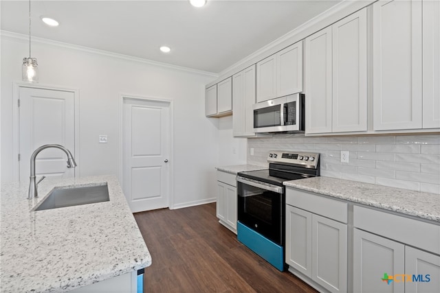 kitchen with light stone countertops, sink, hanging light fixtures, stainless steel appliances, and dark hardwood / wood-style floors