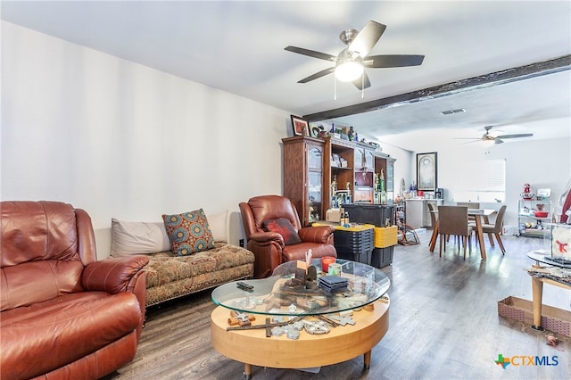 living room with hardwood / wood-style flooring, ceiling fan, and beam ceiling