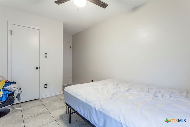 tiled bedroom featuring ceiling fan