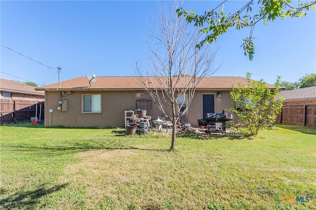 rear view of property featuring a lawn