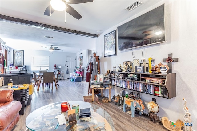 living room with beamed ceiling, wood-type flooring, and ceiling fan