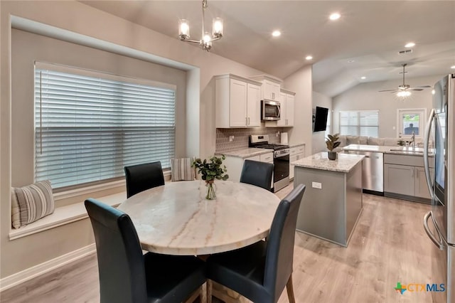 213 Flint Rock Ct, Victoria, TX 77904 - dining room featuring light wood-type flooring, lofted ceiling, recessed lighting, a ceiling fan, and a chandelier