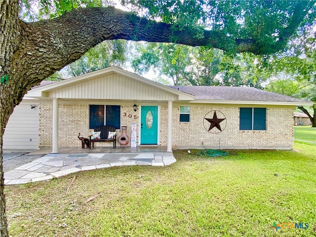 view of front of property featuring a front lawn and a patio