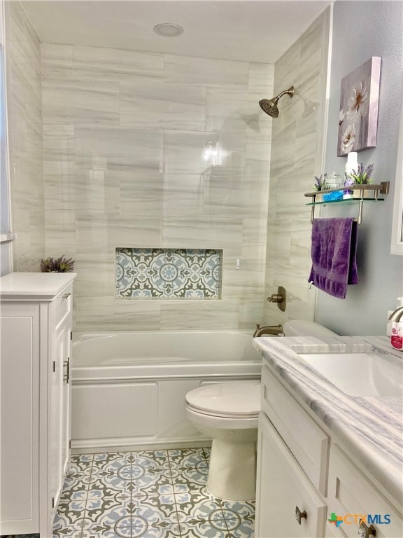 full bathroom featuring toilet, tiled shower / bath combo, vanity, and tile patterned floors