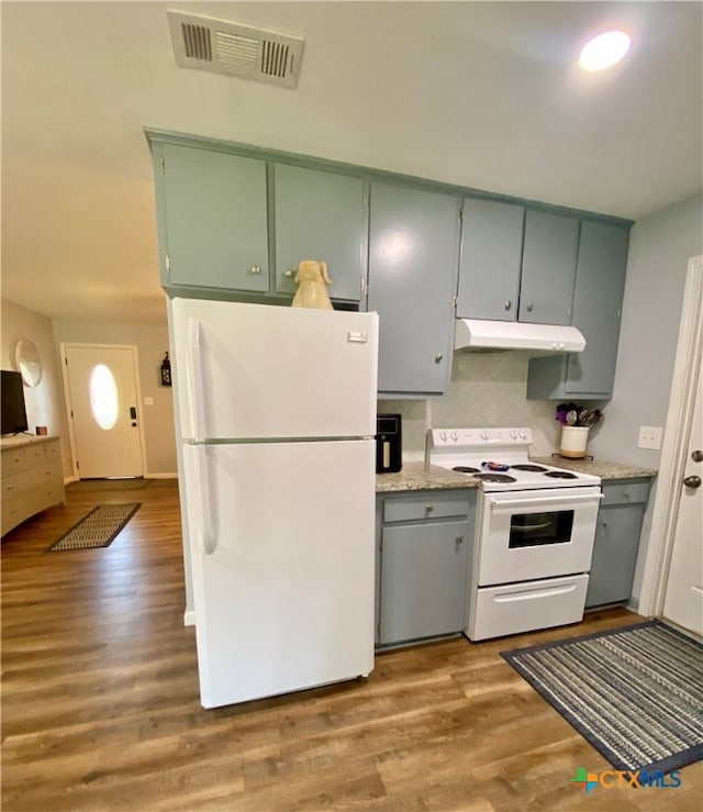 kitchen featuring white appliances, light hardwood / wood-style floors, and tasteful backsplash