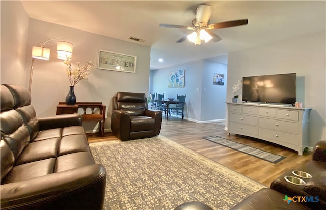 living room with wood-type flooring and ceiling fan