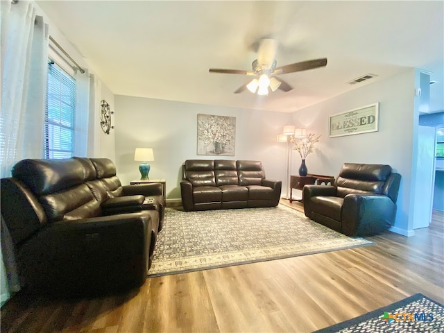 living room featuring hardwood / wood-style floors and ceiling fan