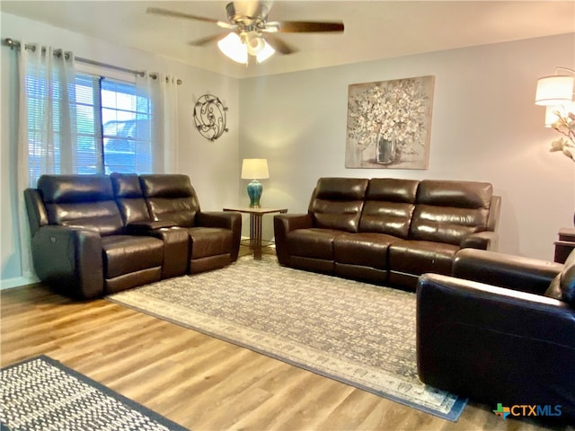 living room featuring wood-type flooring and ceiling fan