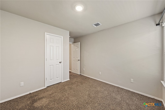 unfurnished room featuring dark colored carpet