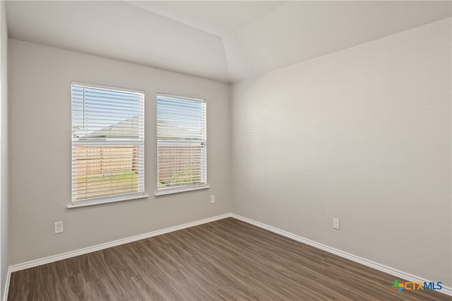 unfurnished room with lofted ceiling and dark wood-type flooring