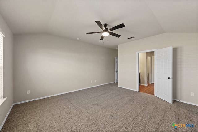 unfurnished bedroom with ceiling fan, carpet, and lofted ceiling