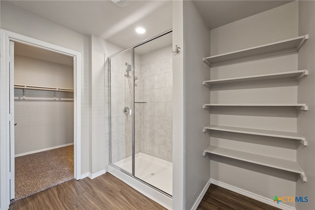 bathroom featuring hardwood / wood-style floors and a shower with door