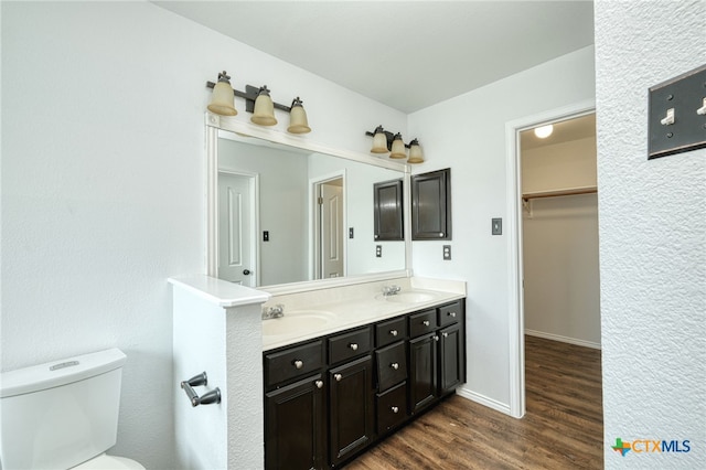 bathroom featuring wood-type flooring, vanity, and toilet