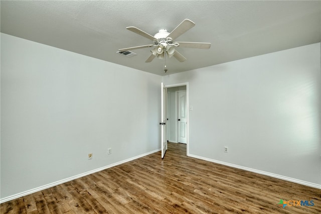 empty room with a textured ceiling, hardwood / wood-style flooring, and ceiling fan